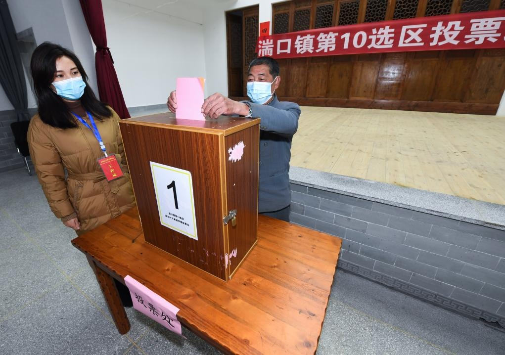 2021年12月14日，在浙江省杭州市臨安區(qū)湍口鎮(zhèn)迎豐村的基層投票點，村民在參加投票，村級監(jiān)察聯(lián)絡(luò)員監(jiān)票。新華社記者 徐昱 攝