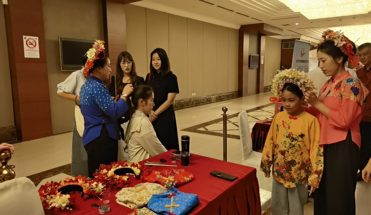 阿拉扎大學(xué)孔子學(xué)院志愿者老師向傳承人學(xué)習(xí)簪花圍。阿拉扎大學(xué)孔子學(xué)院供圖