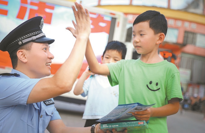 ▲7月10日，江西省吉安市公安局吉州分局組織民警深入轄區(qū)開展安全宣傳，民警向小朋友講解防溺水知識(shí)。朱文杰攝