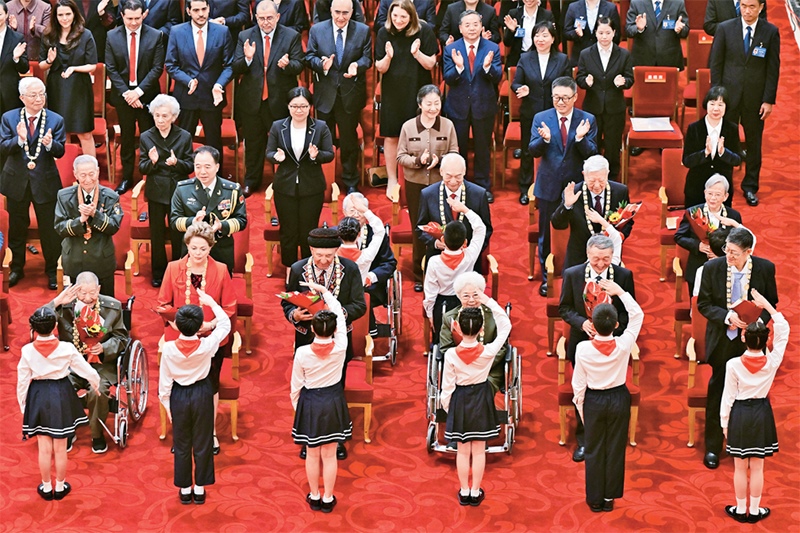 2024年9月29日，中華人民共和國(guó)國(guó)家勛章和國(guó)家榮譽(yù)稱(chēng)號(hào)頒授儀式在北京人民大會(huì)堂隆重舉行。圖為少先隊(duì)員向國(guó)家勛章和國(guó)家榮譽(yù)稱(chēng)號(hào)獲得者敬禮致意。 新華社記者 岳月偉/攝