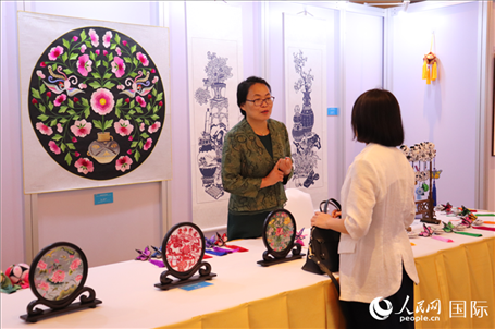 青海非遺文化傳承人向嘉賓介紹展品。人民網(wǎng)實(shí)習(xí)生姚欣可攝