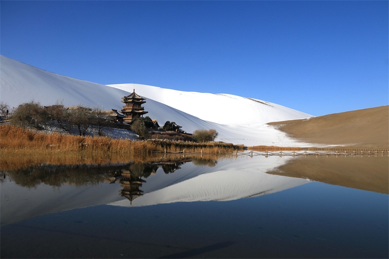 鳴沙山月牙泉景區(qū)雪景。敦煌市委宣傳部供圖，張曉亮攝