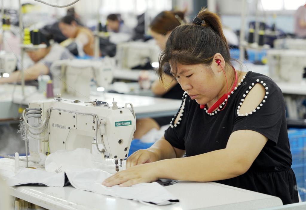 5月20日，村民在李寨村服裝加工廠內(nèi)忙碌。河南省周口市沈丘縣馮營鎮(zhèn)李寨村地處豫東平原。近年來，乘著脫貧攻堅與鄉(xiāng)村振興政策的東風(fēng)，李寨村積極探索產(chǎn)業(yè)發(fā)展模式，通過“龍頭企業(yè)+村集體經(jīng)濟(jì)+農(nóng)戶”的方式，逐漸發(fā)展形成肉牛養(yǎng)殖、設(shè)施農(nóng)業(yè)、服裝加工、康養(yǎng)民宿等產(chǎn)業(yè)，以產(chǎn)業(yè)振興助力鄉(xiāng)村振興。新華社記者 李嘉南 攝