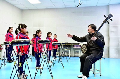 圖為12月30日，在惠民縣胡集鎮(zhèn)第一小學(xué)，老師指導(dǎo)學(xué)生學(xué)習(xí)西河大鼓。新華社記者 郭緒雷攝