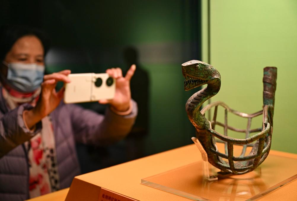 1月14日，觀眾在上海博物館蛇年迎春展拍攝展品蛇綱網(wǎng)狀銅器。新華社發(fā)（陳浩明攝）