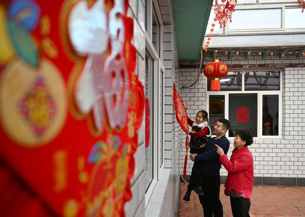 天津市西青區(qū)辛口鎮(zhèn)第六埠村村民在院子里掛“福”字（2024年2月1日攝）。新華社記者 趙子碩 攝