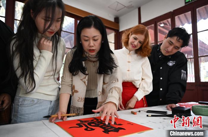 1月20日，西泠印社社員李硯（左二）為外籍留學(xué)生講述蛇年福字貼創(chuàng)作靈感。當日，來自巴西、馬來西亞、加納、哈薩克斯坦的外籍留學(xué)生在浙江杭州西泠印社體驗福貼、春聯(lián)和篆刻，感受古老的中國傳統(tǒng)文化。中新社記者 王剛 攝