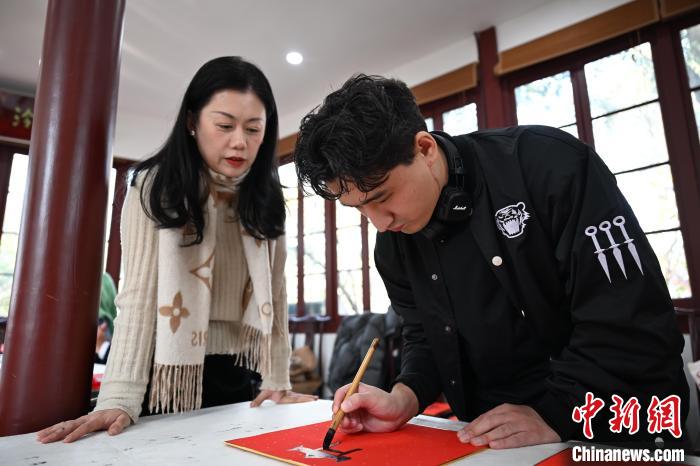 1月20日，外籍留學(xué)生在西泠印社社員李硯指導(dǎo)下寫福。當日，來自巴西、馬來西亞、加納、哈薩克斯坦的外籍留學(xué)生在浙江杭州西泠印社體驗福貼、春聯(lián)和篆刻，感受古老的中國傳統(tǒng)文化。中新社記者 王剛 攝