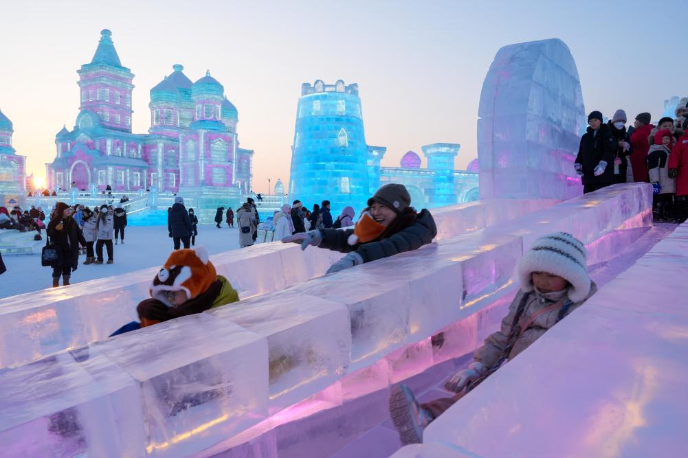 游客在哈爾濱冰雪大世界園區(qū)內體驗冰滑梯。新華社發(fā)