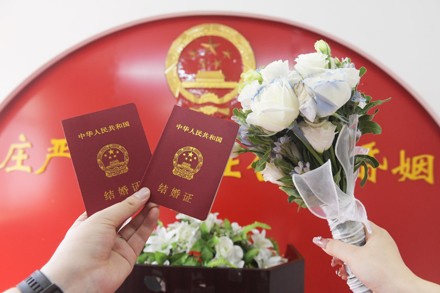 2024年8月10日，一對新人在河北石家莊新樂市民政局婚姻登記處領(lǐng)取結(jié)婚證后拍照留念。新華社發(fā)（賈敏杰攝）