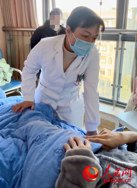 鄧茜查房時(shí)詢問患者情況。人民網(wǎng)記者 金慧慧攝