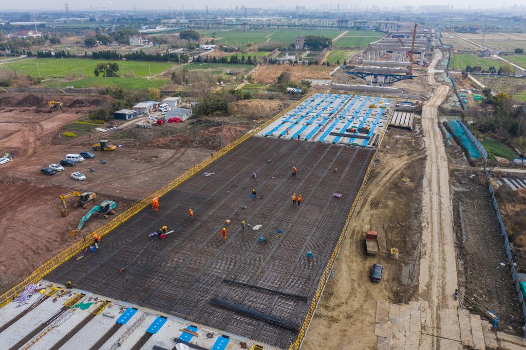 3月7日，在524國(guó)道秀洲王江涇至新塍公路工程TJ02標(biāo)段，作業(yè)人員正在進(jìn)行60米鋼混組合梁現(xiàn)澆橋面板鋼筋焊接及綁扎作業(yè)（無(wú)人機(jī)照片）。新華社記者 徐昱 攝