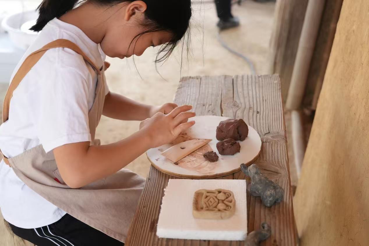 游客制作良渚特色陶藝品。良渚博物院供圖