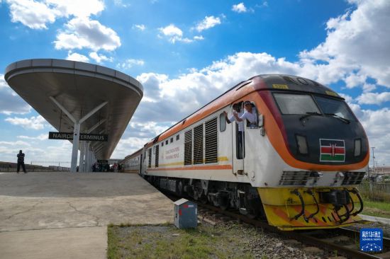 5月31日，在蒙內(nèi)鐵路內(nèi)羅畢站，機(jī)車駕駛員蔣立平（右）和博爾在即將開往蒙巴薩的E2次列車上揮手致意。新華社記者 楊光 攝